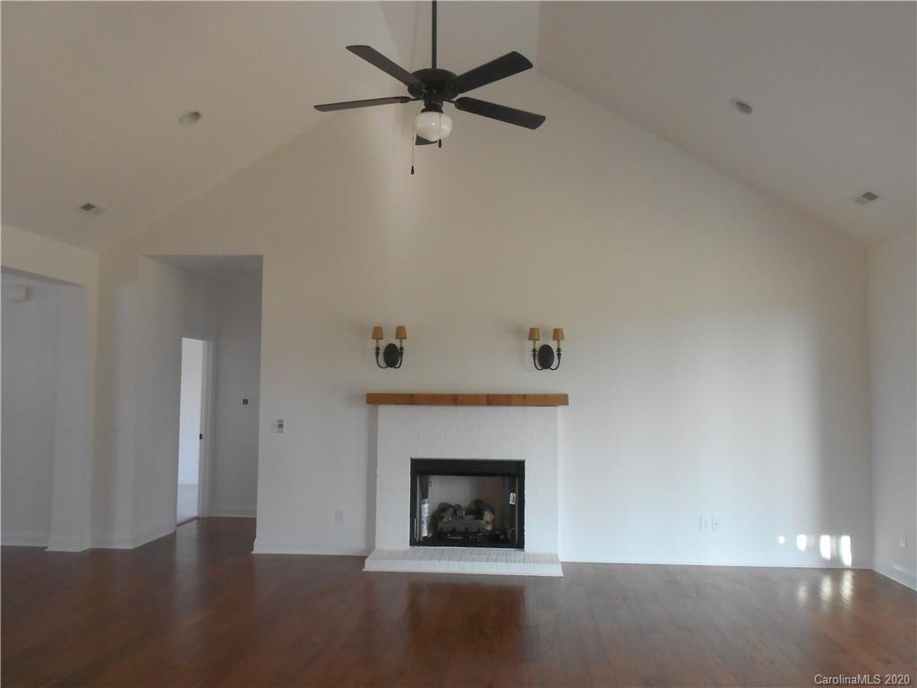 5606 Unionville-Brief Road Monroe, NC 28110 - Photo 4 of 21 a living room with a fireplace and a ceiling fan