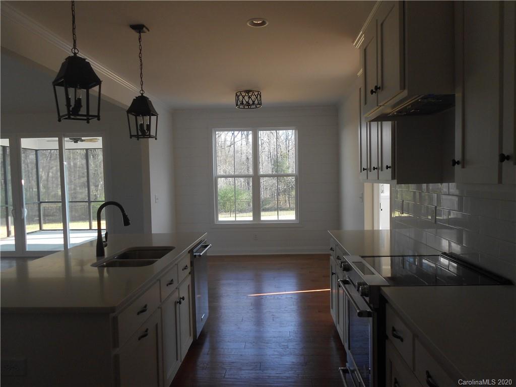 5606 Unionville-Brief Road Monroe, NC 28110 - Photo 8 of 21 a kitchen with stainless steel appliances granite countertop a sink a stove and a wooden floors