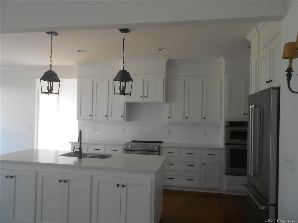5606 Unionville-Brief Road Monroe, NC 28110 - Photo 9 of 21 a kitchen with stainless steel appliances a sink a refrigerator a center island and cabinets
