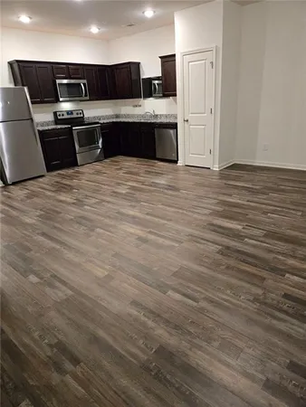 a large kitchen with stainless steel appliances a sink and a refrigerator