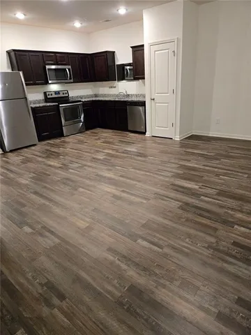 a large kitchen with stainless steel appliances a sink and a refrigerator