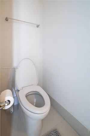 a white toilet sitting next to a shower