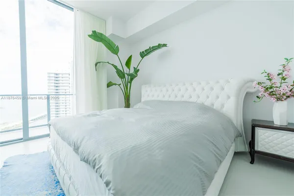 a large bed sitting in a bedroom next to a window