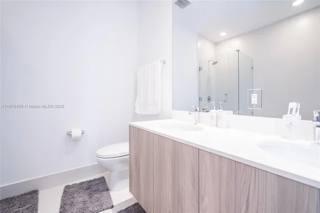 a bathroom with a sink a toilet and a large mirror