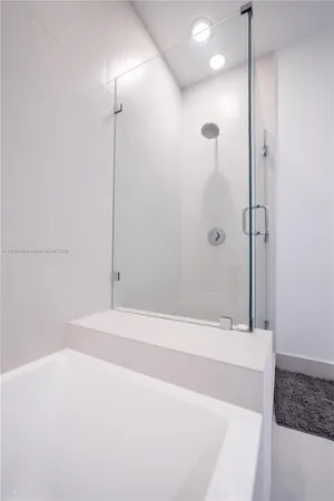 a bathroom with a shower and a glass door