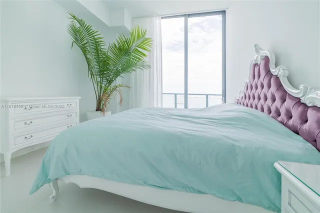 a bedroom with a bed and a potted plant
