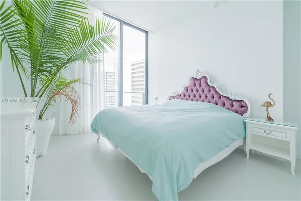 a bed sitting in a bedroom next to a window