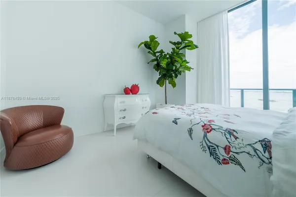 a bedroom with a bed and a potted plant