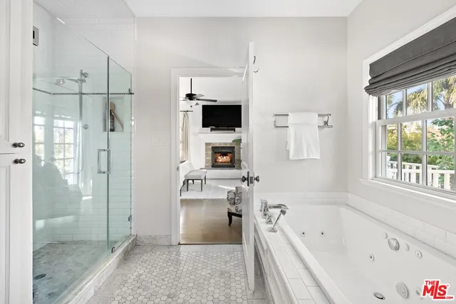 a bathroom with a tub a sink and a large mirror