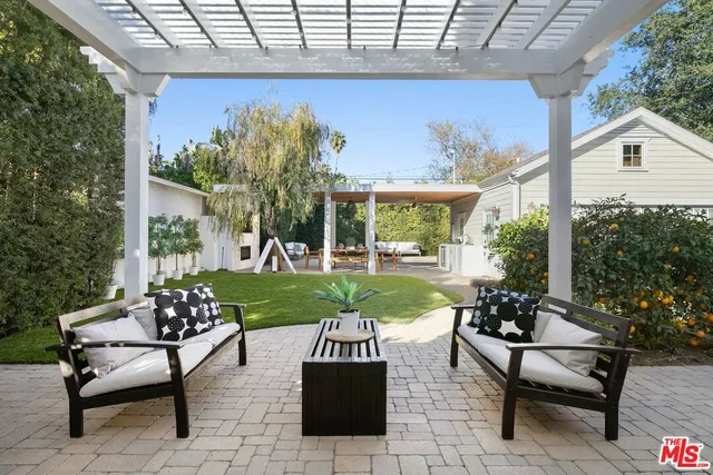 a view of a patio with couches table and chairs potted plants and palm tree