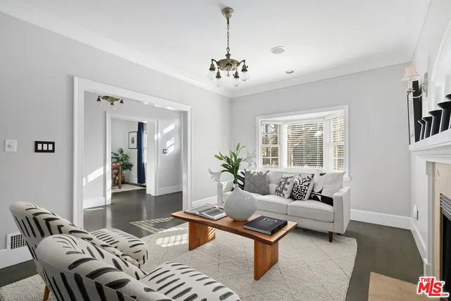 a living room with furniture a chandelier and a window