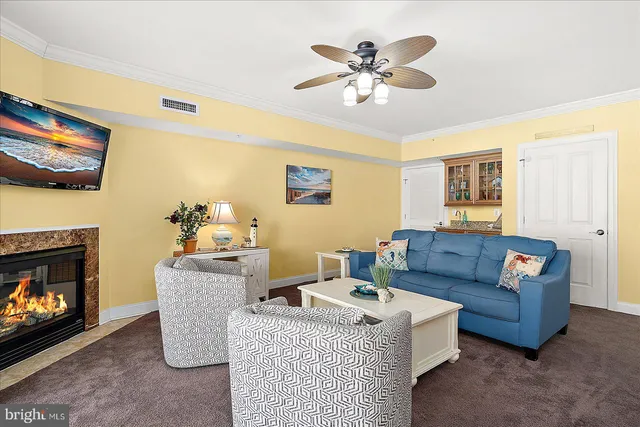 a living room with furniture kitchen view and a large window