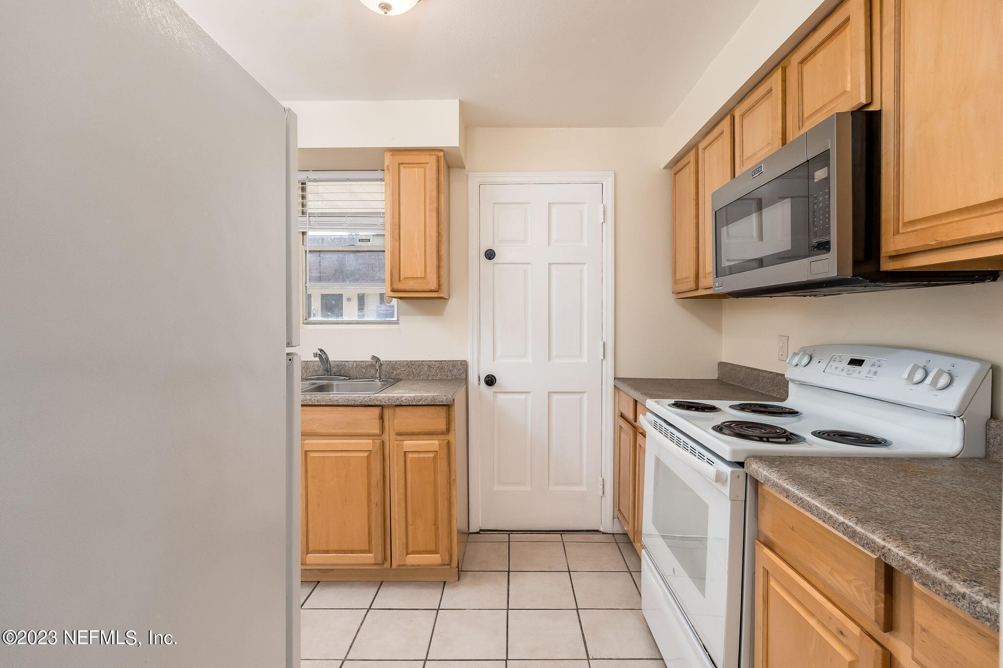 1735 El Camino Road, Unit 5 Jacksonville, FL 32216 - Photo 3 of 26 a kitchen with stainless steel appliances granite countertop a stove a sink and a microwave
