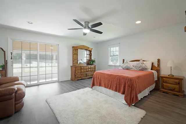 a spacious bedroom with a bed a couch and a large window