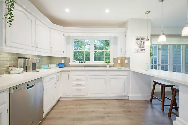 a kitchen with granite countertop white cabinets and white appliances