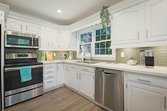 a kitchen with stainless steel appliances granite countertop a stove sink and cabinets
