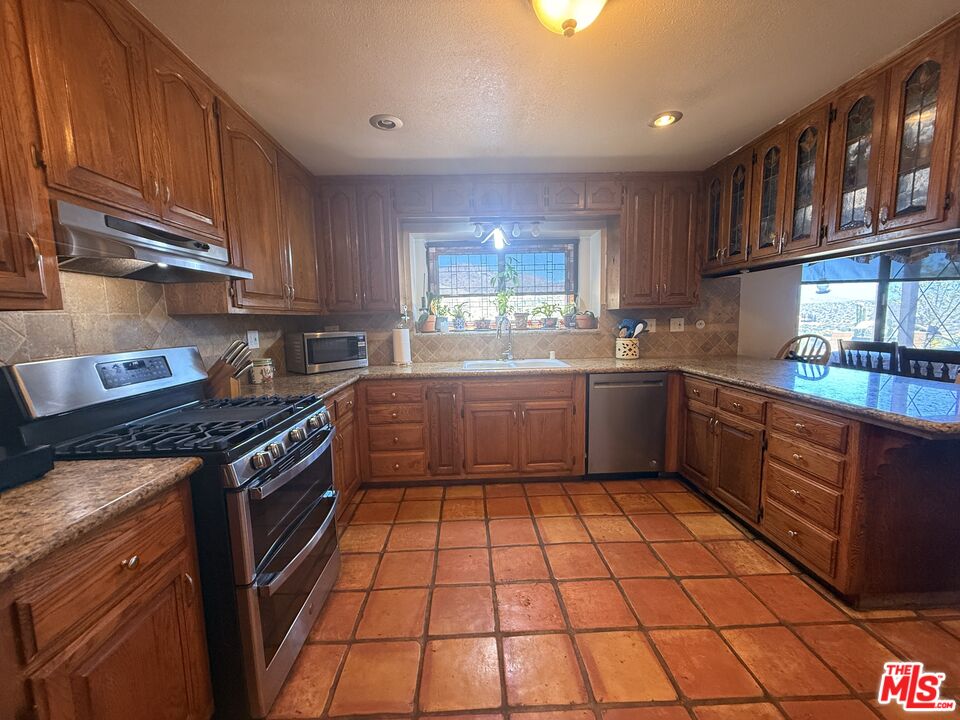 33931 Hanawalt Road Agua Dulce, CA 91390 - Photo 6 of 22 a kitchen with stainless steel appliances granite countertop a stove a sink dishwasher and a refrigerator