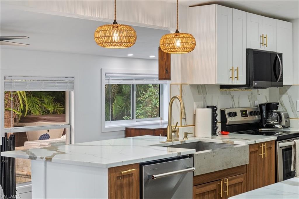 2123 Holiday Lane Naples, FL 34104 - Photo 12 of 43 Kitchen featuring stainless steel appliances, backsplash, light stone countertops, pendant lighting, and recessed lighting