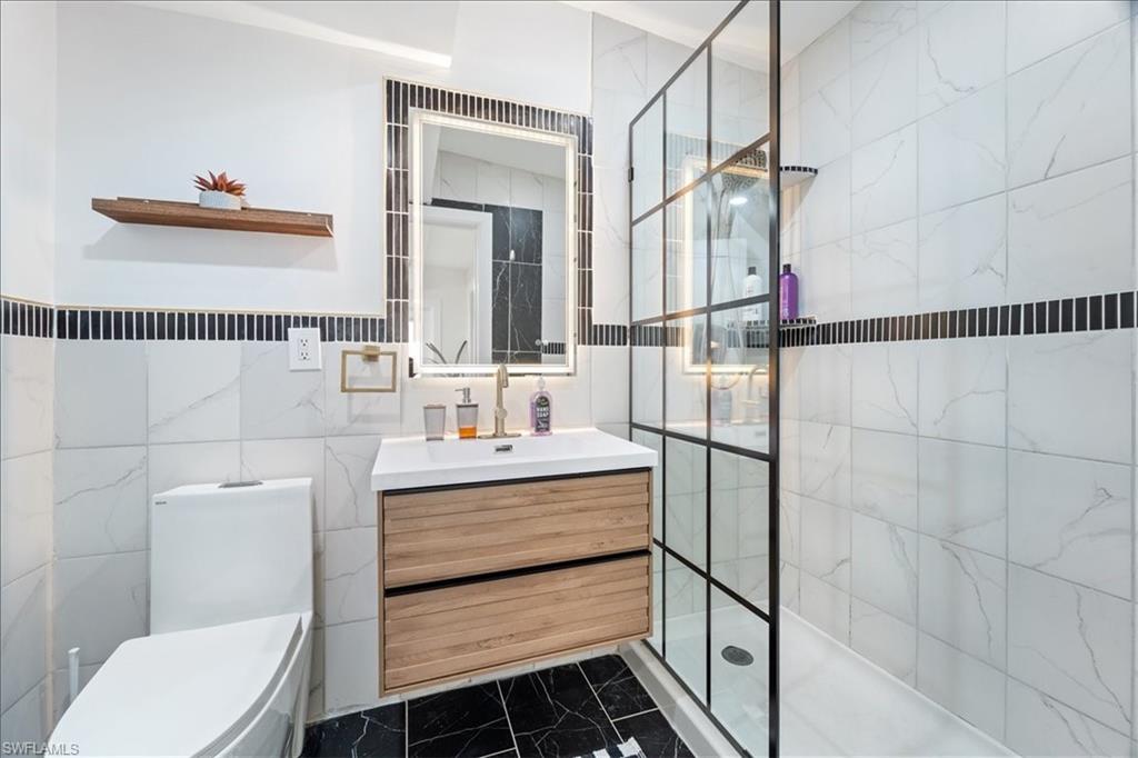 2123 Holiday Lane Naples, FL 34104 - Photo 20 of 43 a bathroom with a sink toilet and shower