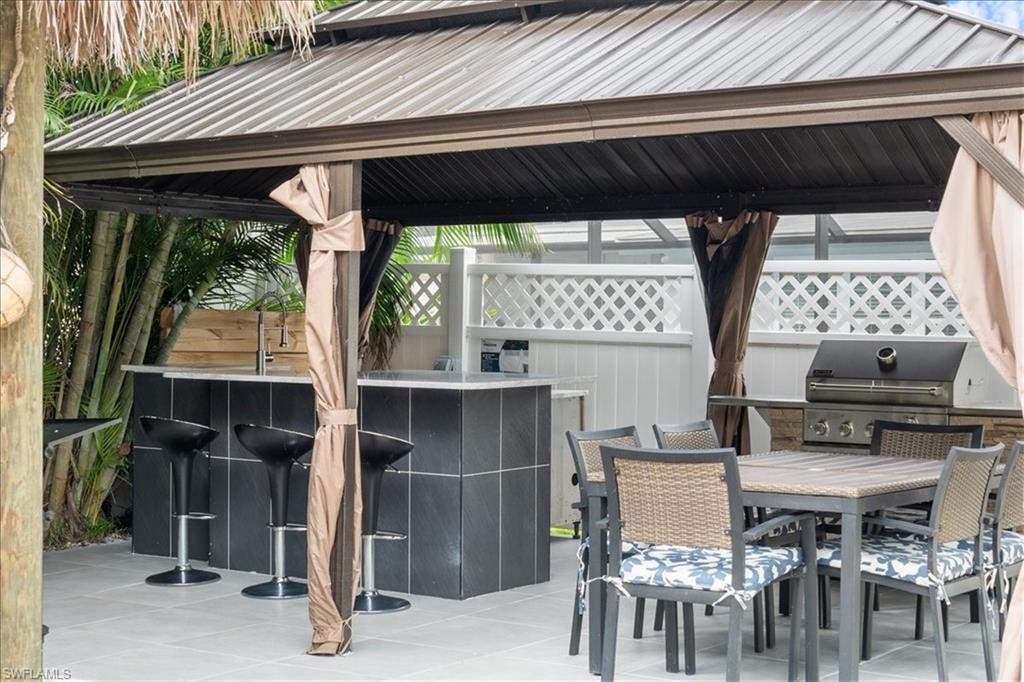 2123 Holiday Lane Naples, FL 34104 - Photo 30 of 43 View of patio featuring outdoor dining area and area for grilling