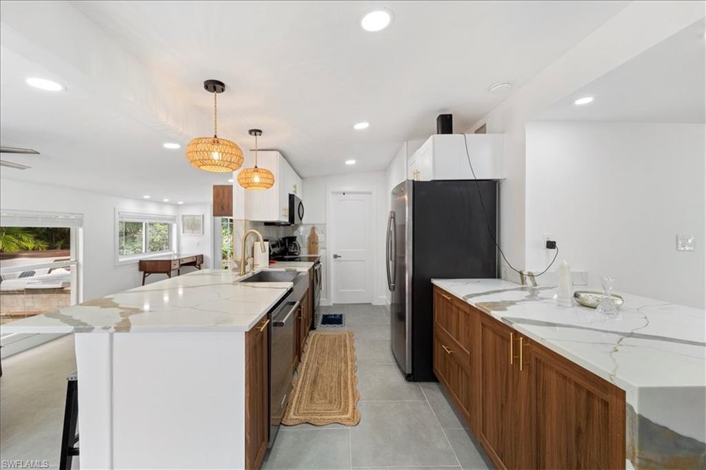 2123 Holiday Lane Naples, FL 34104 - Photo 10 of 43 a kitchen with stainless steel appliances kitchen island granite countertop a sink a refrigerator and a stove