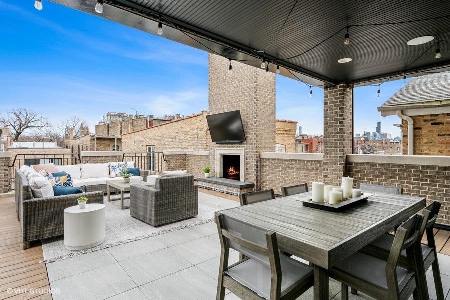 2107 North Kenmore Avenue Chicago, IL 60614 - Photo 4 of 7 a kitchen with a table chairs and flat screen tv