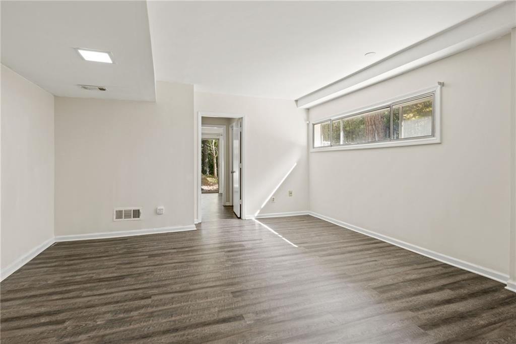 705 Edgewater Trail Sandy Springs, GA 30328 - Photo 8 of 36 a view of an empty room with wooden floor and a window