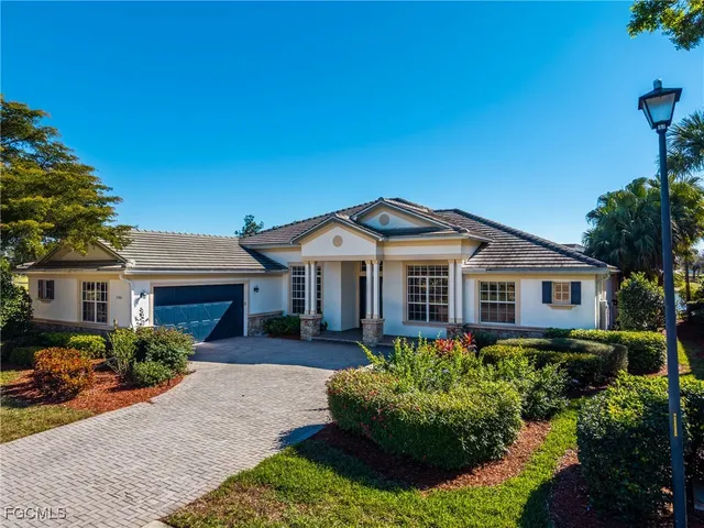 a front view of a house with a yard and potted plants