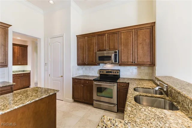 a kitchen with granite countertop a stove sink and microwave