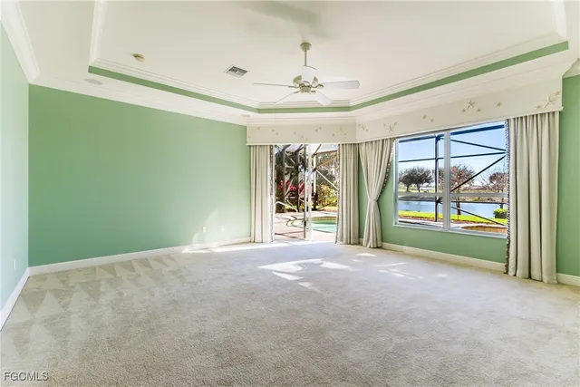 a view of empty room with floor to ceiling window and ceiling fan