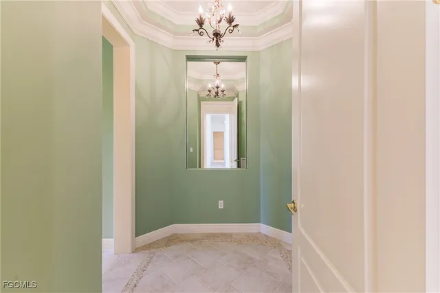 a view of a hallway with windows and chandelier