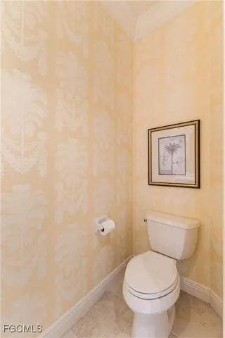 a white toilet sitting next to a white wall