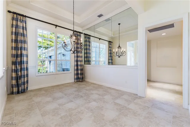 a view of an empty room with a window and chandelier