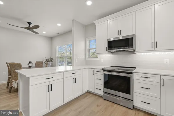 a kitchen with white cabinets stainless steel appliances and sink