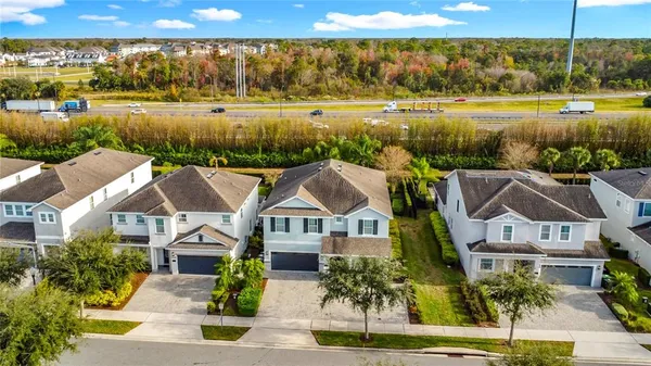an aerial view of residential houses with outdoor space and lake view
