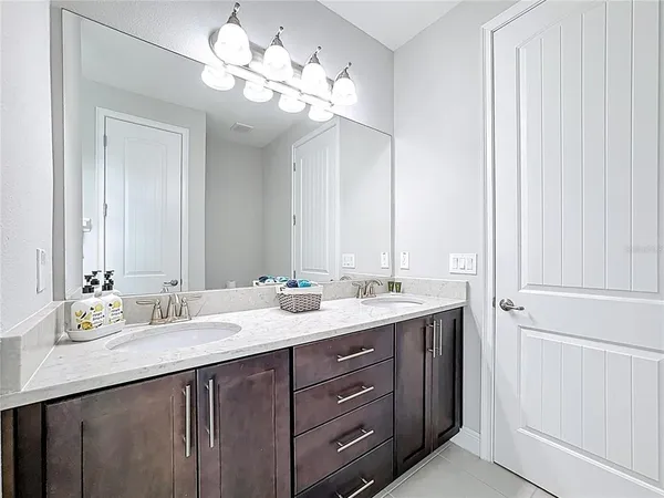 a view of house in front of a big yard with large trees