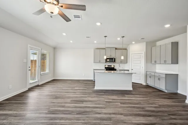 a large kitchen with stainless steel appliances kitchen island wooden cabinets and granite counter tops