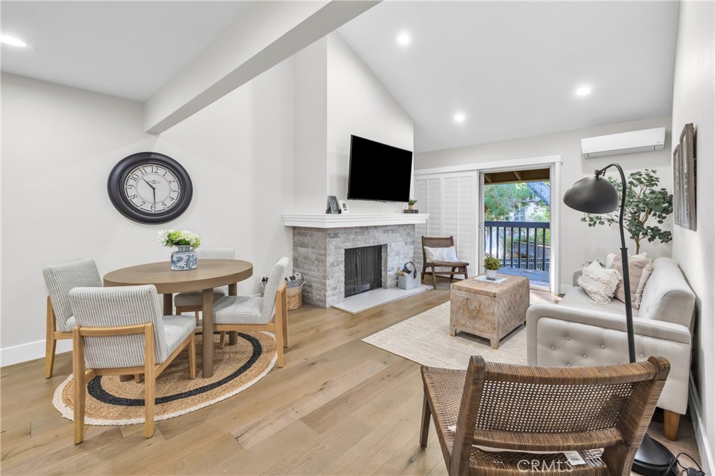 7890 East Spring Street, Unit 10F Long Beach, CA 90815 - Photo 12 of 31 a living room with furniture a flat screen tv and a fireplace