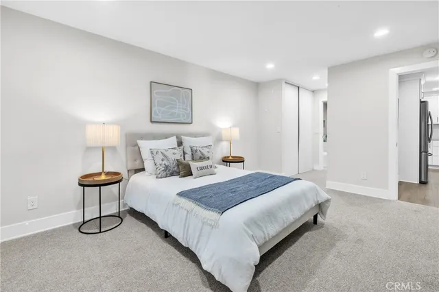 a spacious bedroom with a bed and a lamp