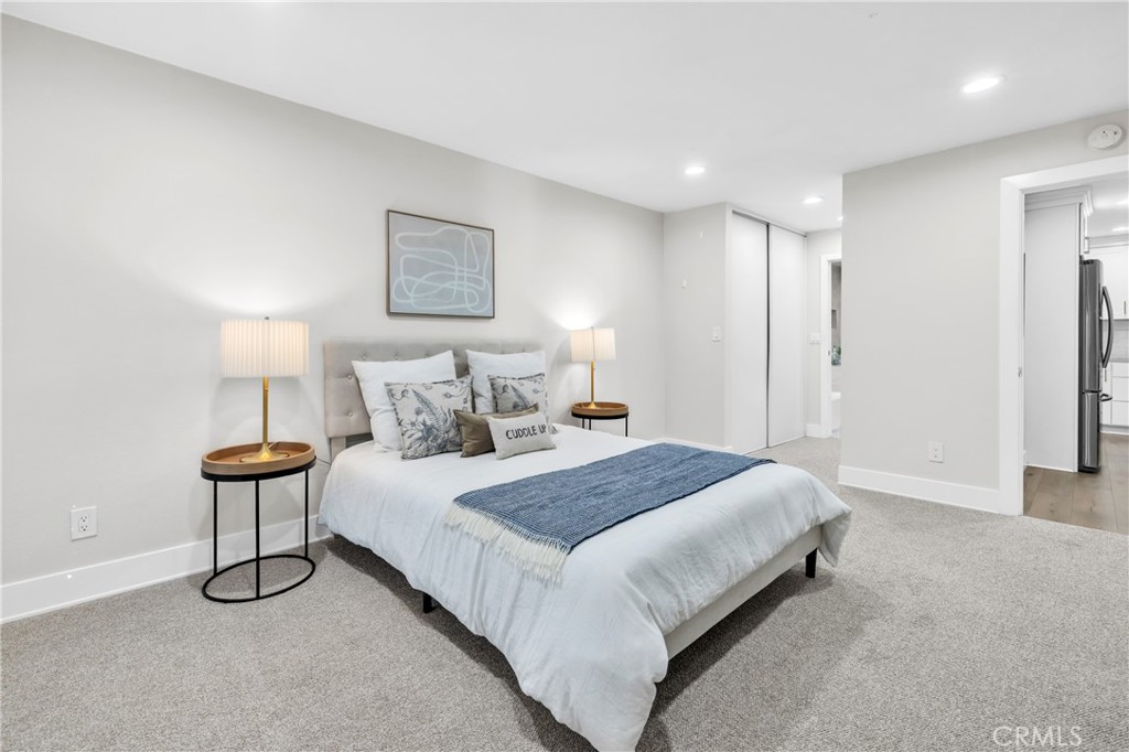 7890 East Spring Street, Unit 10F Long Beach, CA 90815 - Photo 14 of 31 a spacious bedroom with a bed and a lamp