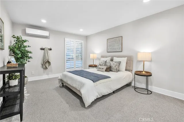 a bedroom with a bed and a potted plant