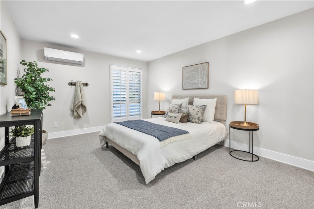 7890 East Spring Street, Unit 10F Long Beach, CA 90815 - Photo 16 of 31 a bedroom with a bed and a potted plant