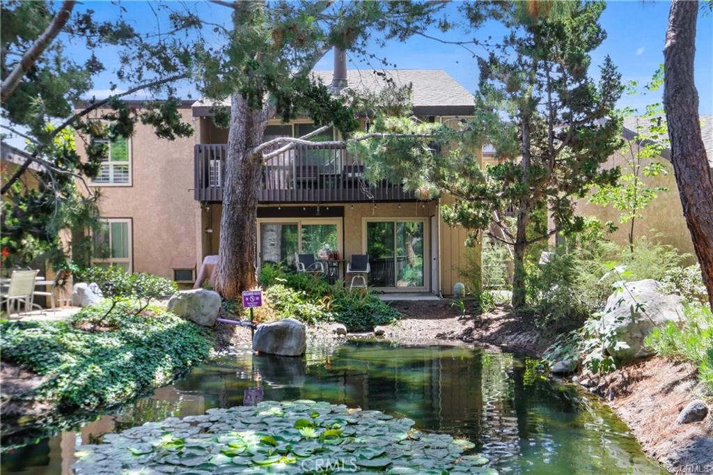 7890 East Spring Street, Unit 10F Long Beach, CA 90815 - Photo 25 of 31 a front view of a house with a yard and potted plants