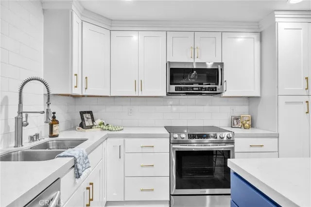 a kitchen with granite countertop a stove a microwave a sink and cabinets