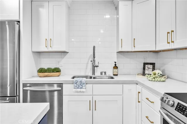 a kitchen with stainless steel appliances granite countertop a sink a stove and cabinets