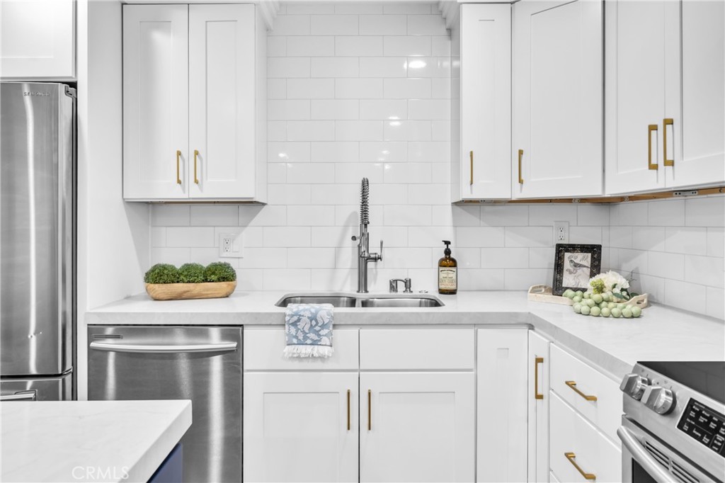 7890 East Spring Street, Unit 10F Long Beach, CA 90815 - Photo 4 of 31 a kitchen with stainless steel appliances granite countertop a sink a stove and cabinets