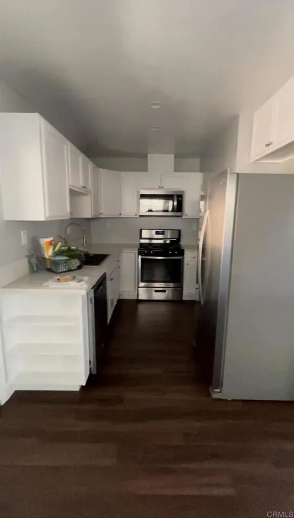 1419 Flo Drive Alpine, CA 91901 - Photo 22 of 27 a kitchen with a refrigerator stove and wooden cabinets