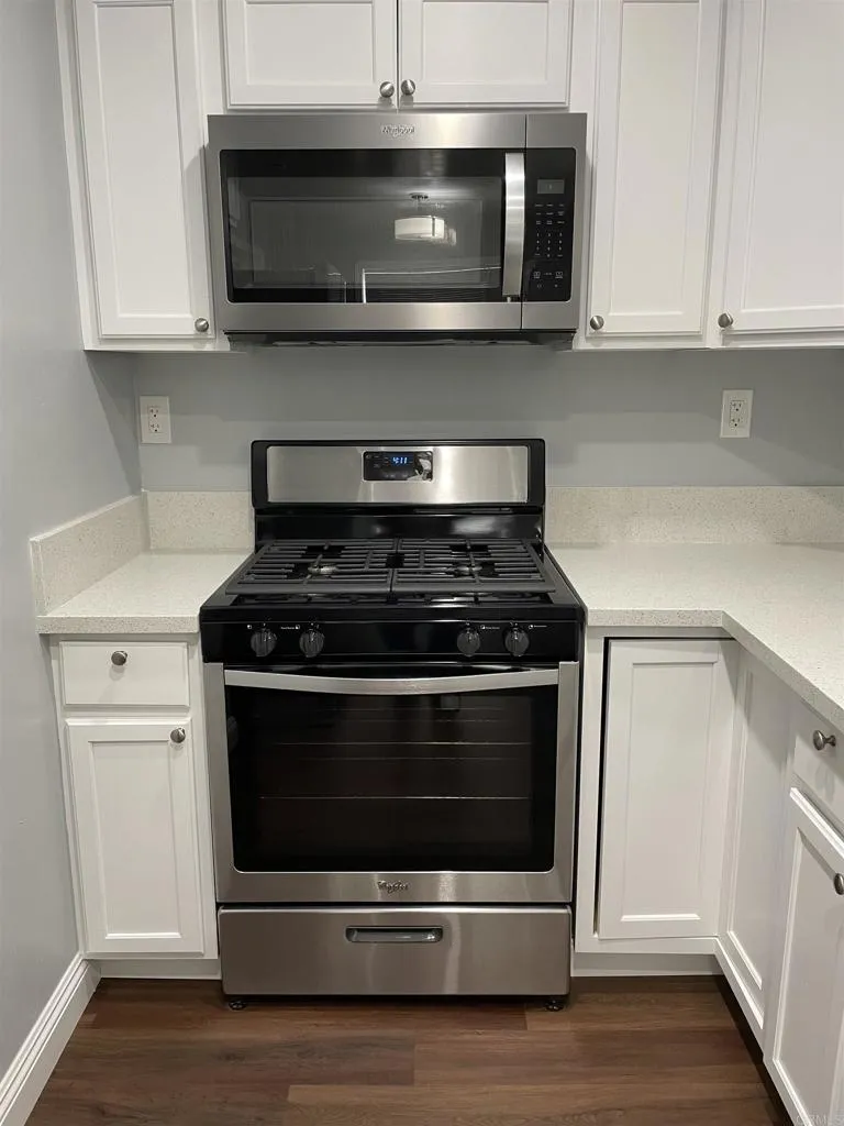 1419 Flo Drive Alpine, CA 91901 - Photo 9 of 27 a stove top oven sitting inside of a kitchen and white cabinets