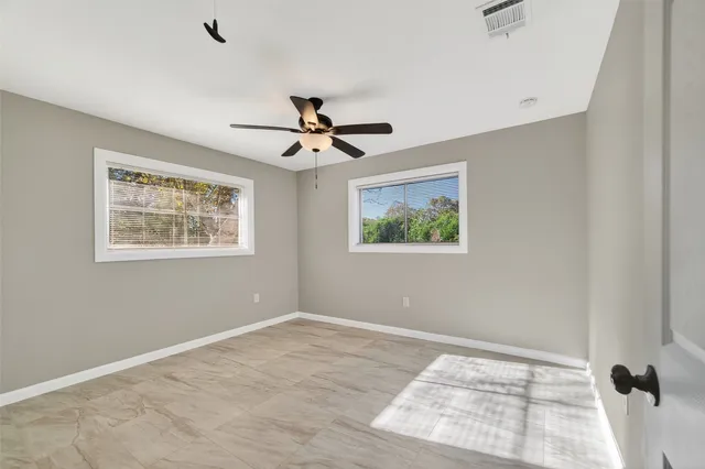 a view of a big room with wooden floor and windows