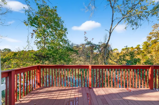 a balcony with wooden floor and yard in the back